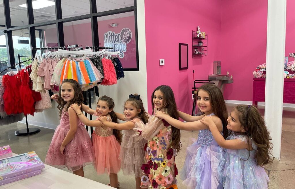 Girls browsing clothing racks at party venue