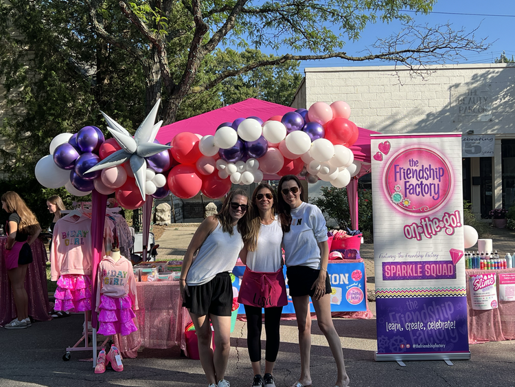 Girls posing near pink balloon decorated party entrance