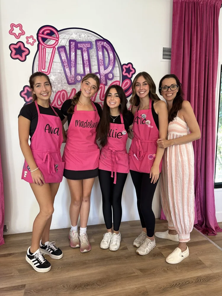 Girls posing near pink balloon decorated party entrance